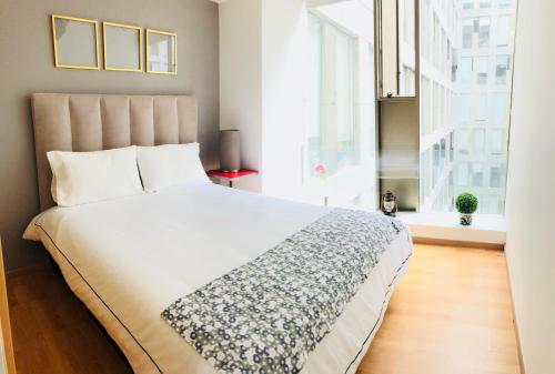 Un dormitorio con una gran cama blanca y una ventana en Boutique Apartment Downtown 628, en Ciudad de México