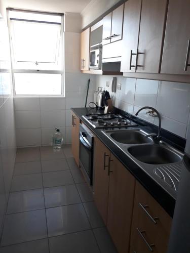 a kitchen with a sink and a stove at Depto. Nautilus Piso 11 in Iquique