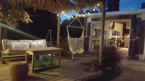 a porch with a hammock and a swing at Bidieen Inn Uruguay in Carrasco