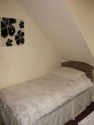 a bed in a attic with a picture on the wall at Kilkerran Guest House in Ayr