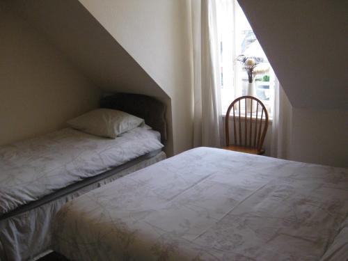 a small bedroom with a bed and a window at Kilkerran Guest House in Ayr