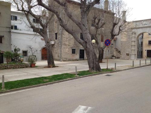 an empty street with trees on the side of a building at cres art studio kuning apartment in Cres