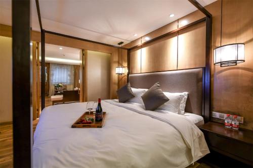 a bedroom with a large white bed with a tray on it at Water Hotel, Pingyao in Pingyao