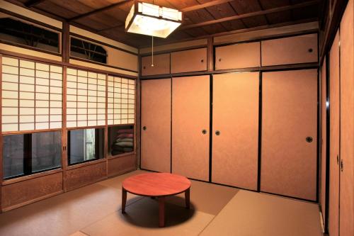 um quarto com um banco vermelho e armários em Kiyomizuan 清水庵 車庫2台可 ビフォアアフターの匠 坂田基禎さん改築の京町家 em Quioto