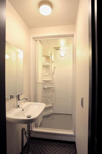 a white bathroom with a sink and a shower at Kiyomizuan 清水庵 車庫2台可 ビフォアアフターの匠 坂田基禎さん改築の京町家 in Kyoto