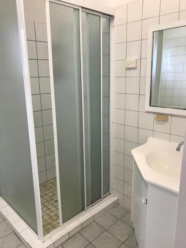 a bathroom with a shower, sink, and toilet at Tramway Motel in Sarina