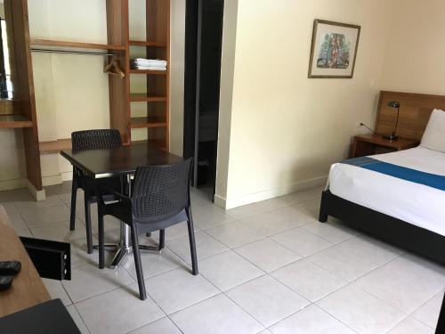 a hotel room with a bed and a table and chairs at Domicilio Lorenzo in Davao City
