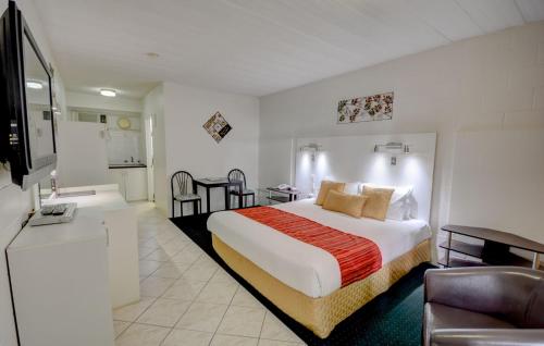 um quarto de hotel com uma cama e uma sala de estar em Elkira Court Motel em Alice Springs