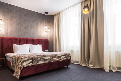 
a hotel room with a bed and a dresser at New Star Hotel in Perm

