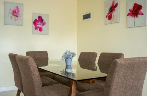 a dining room table with chairs and a vase of flowers at Alicia Apartelle in Cebu City