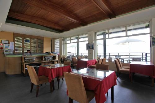 a restaurant with tables and chairs with red table cloth at Sunnydale B&B in Ren'ai