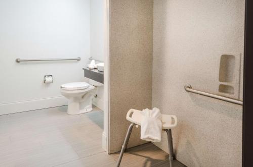 a bathroom with a toilet and a towel on the door at Motel 6-Mobile, AL in Tillmans Corner