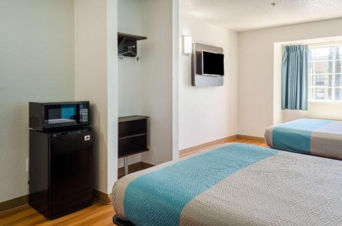 a hotel room with two beds and a television at Motel 6-Mobile, AL in Tillmans Corner
