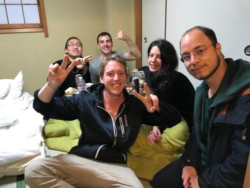 a group of people sitting on a couch posing for a picture at Lazy House in Okayama