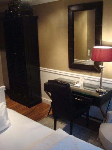 a bedroom with a desk with a lamp and a mirror at Hotel Sir & Lady Astor in Düsseldorf