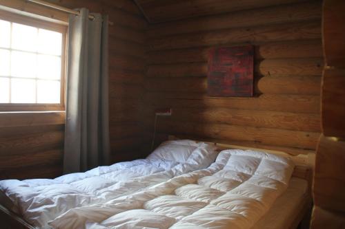 a large bed in a room with a window at Fosheim Hytter in Ron