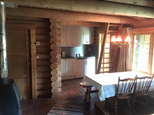 a kitchen with a table and chairs in a cabin at Fosheim Hytter in Ron