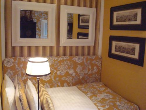 a living room with a couch and a lamp at Hotel Sir & Lady Astor in Düsseldorf