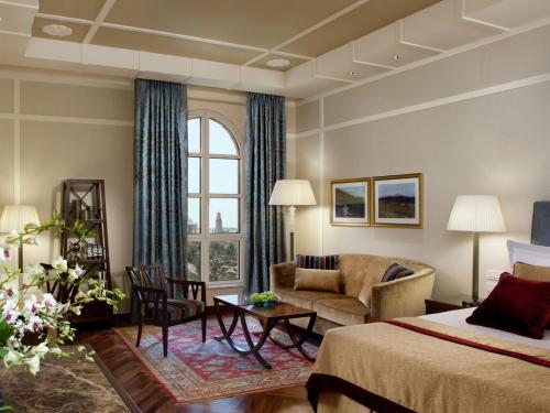 een hotelkamer met een bed en een bank bij King David Hotel Jerusalem in Jeruzalem