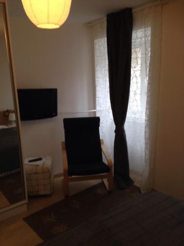 a living room with a chair and a window at Apartments Kremenic in Cres