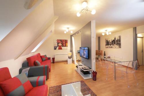 a living room with red furniture and a tv at COLMARAPPART Grand'Rue in Colmar