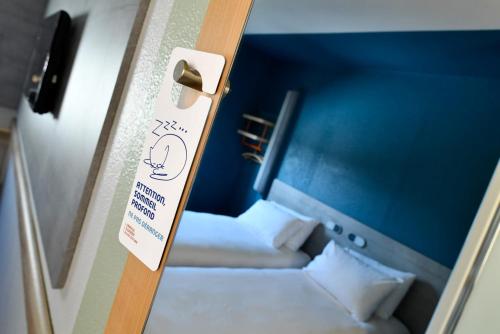 a room with two beds with a sign on the door at Ibis Budget Le Havre Les Docks in Le Havre