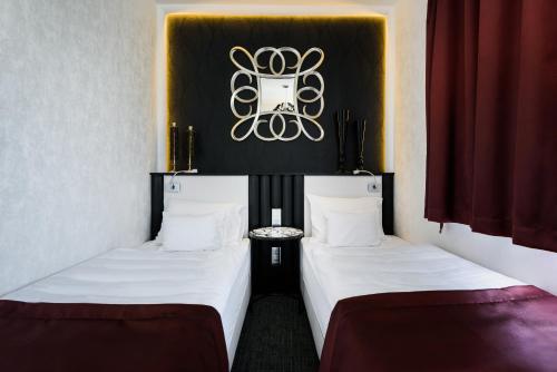 two beds sitting next to each other in a room at RQ Boutique & Unique Hotel in Győr