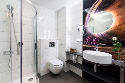 a bathroom with a sink and a toilet and a mirror at RQ Boutique & Unique Hotel in Győr