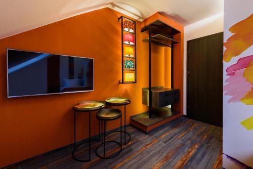 a room with two stools and a flat screen tv at RQ Boutique & Unique Hotel in Győr