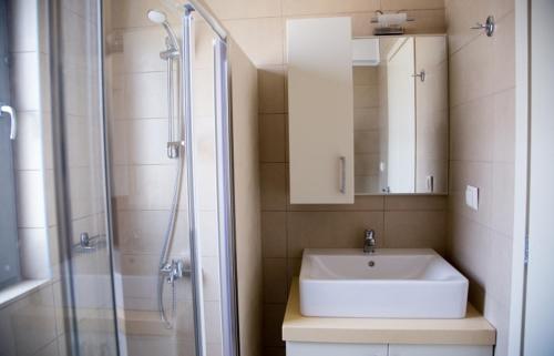 a bathroom with a sink and a glass shower at Lagada Resort in Makry Gialos