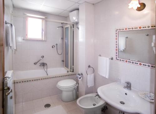a white bathroom with a sink and a toilet and a shower at Hotel delle Palme in Letojanni