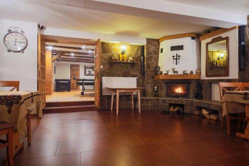 a living room with a fireplace and a clock on the wall at Willa Wincentówka w sercu Uzdrowiska in Szczawnica