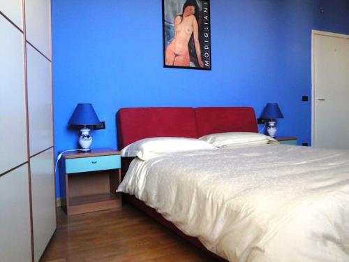 a blue bedroom with a bed with a red headboard at cozy private room in Florence