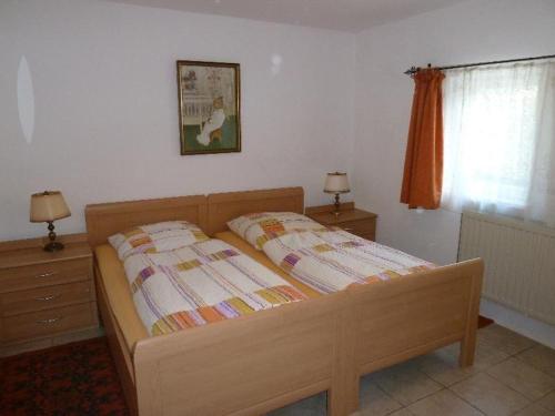 ein Schlafzimmer mit einem Bett mit zwei Nachttischen und einem Fenster in der Unterkunft Grenzhof, Elisabethwohnung in Westerland