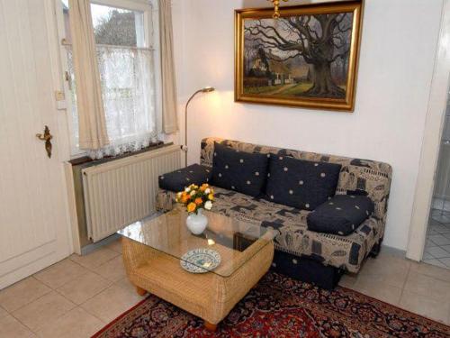 ein Wohnzimmer mit einem Sofa und einem Tisch in der Unterkunft Grenzhof, Elisabethwohnung in Westerland