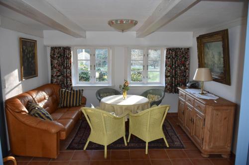 a living room with a couch and a table and chairs at Hackerhof-Mittewohnung in Morsum