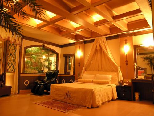 a bedroom with a bed and a chair in it at Swan Lake Motel in Guishan