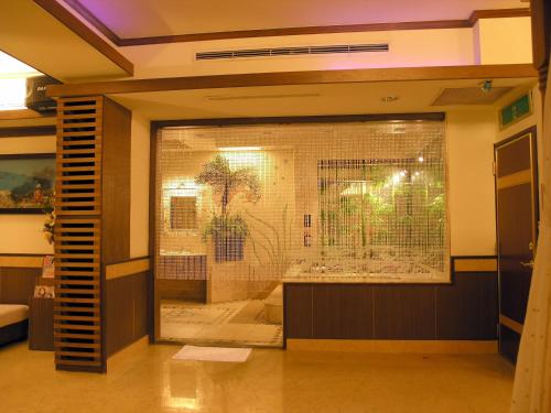 a large glass window in a room with a bird cage at Swan Lake Motel in Guishan