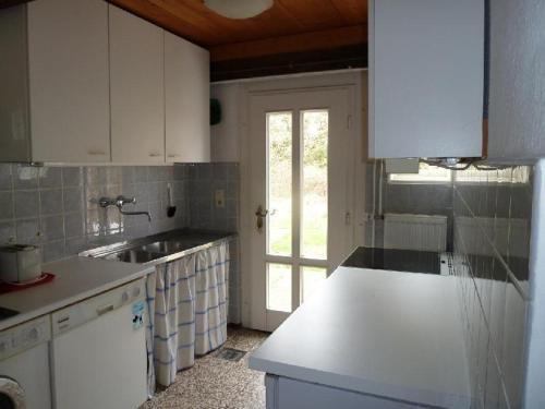 a kitchen with white cabinets and a sink and a window at Hackerhof-Westwohnung in Morsum