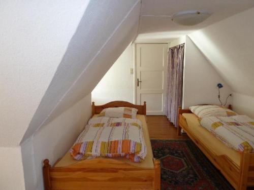 ヴェスターラントにあるGrenzhof-Kapitaenswohnungのベッドルーム(ベッド2台付)が備わる屋根裏部屋です。