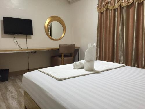 Schlafzimmer mit einem Bett mit einem Spiegel und einem TV in der Unterkunft Meaco Hotel - Solano in Solano