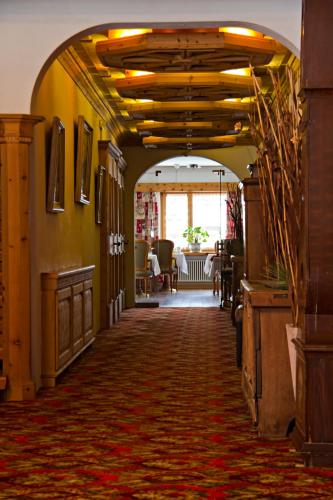 a hallway with an archway in a building with a table at Hotel Nolda in St. Moritz