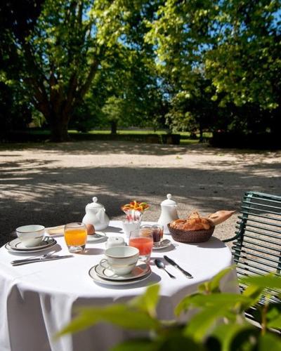 - une table blanche avec de la nourriture et des boissons dans l'établissement Hotel Château Des Alpilles, à Saint-Rémy-de-Provence