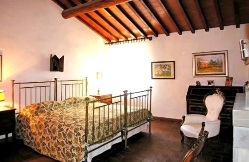 a bedroom with a bed and a chair and a piano at Casale Le Torri in Torri