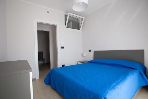 a bedroom with a blue bed in a white room at Green House in Barletta