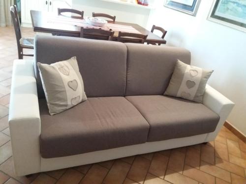 a gray couch with pillows in a living room at Villa Posta Vecchia in Loreo