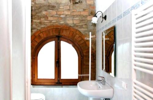 ein Bad mit einem Waschbecken und einem Spiegel in der Unterkunft Podere Grossi in Rabatta