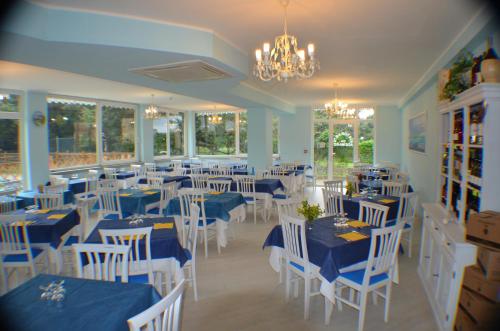 una sala da pranzo con tavoli blu e sedie bianche di Hotel Paradiso Verde a Marina di Bibbona