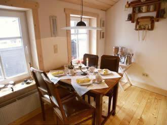 a dining room with a table and chairs and a kitchen at Pension Picco-Bello in Clausthal-Zellerfeld