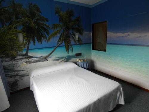 Un dormitorio con una cama blanca y una pintura de una playa en Motel Caldas en Caldas de Reis